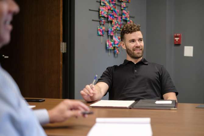 Greg smiling during a meeting.