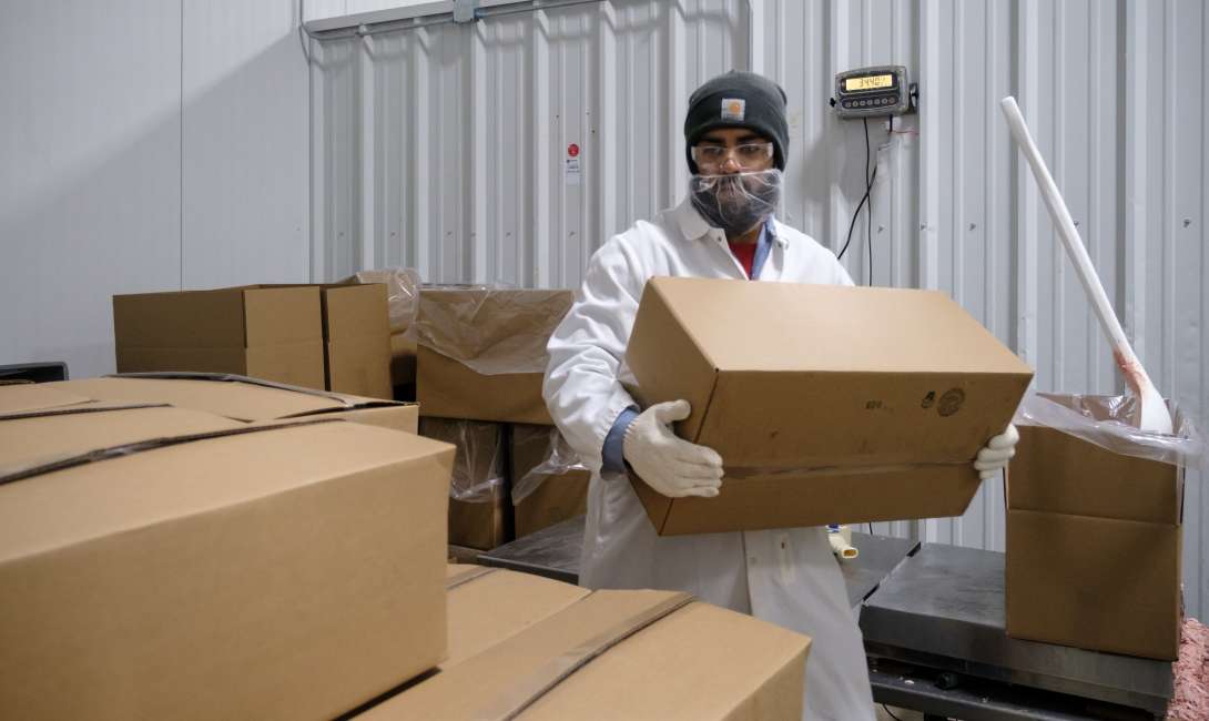 An employee lifting product boxes for the other category.